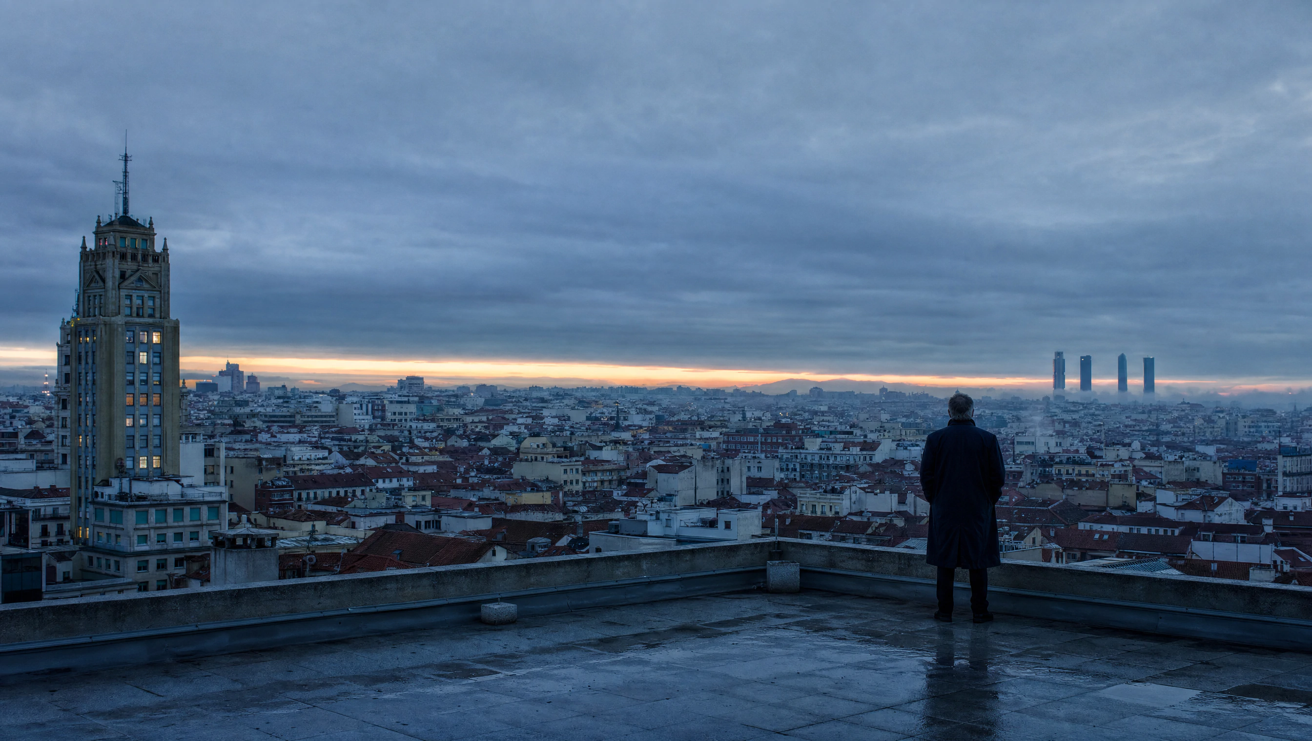 Director de agencia inmobiliaria contemplando el skyline panorámico de una gran ciudad al amanecer